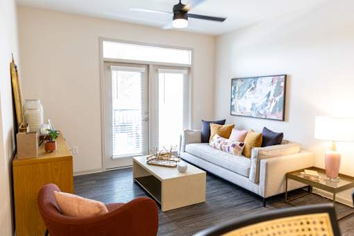 Living room with balcony access and modern furnishings at The Crest at Acworth Apartments, Acworth