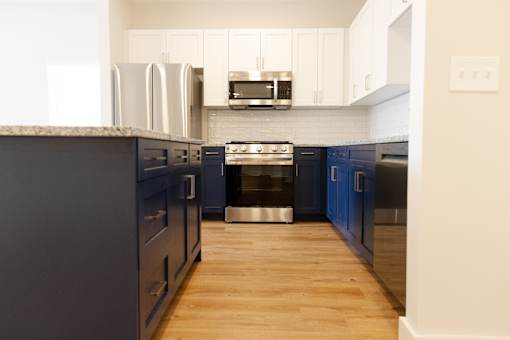 A kitchen with dark blue cabinets and a white countertop.
