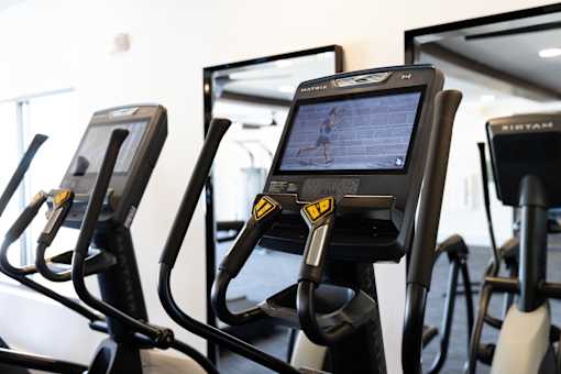 A row of stationary bikes in a gym.