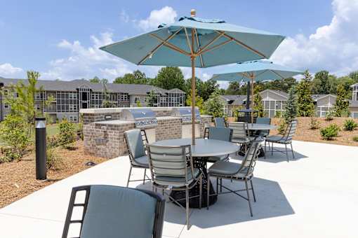 A patio with a table and chairs under an umbrella.