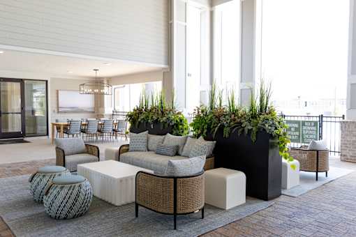A modern outdoor seating area with a variety of furniture and plants.
