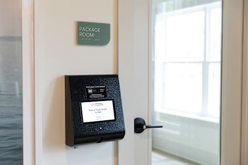A package room sign is on a wall above a door.