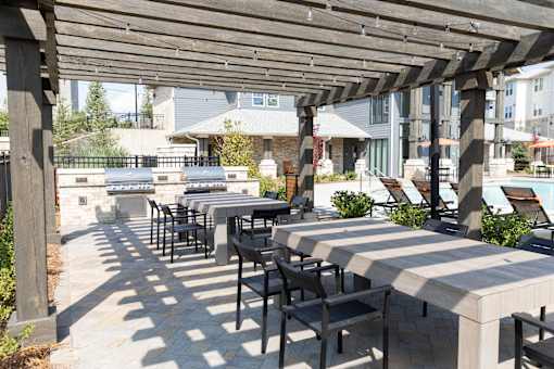 Outdoor grilling area with pergola and dining tables at The Crest at Acworth Apartments, Georgia, 30102