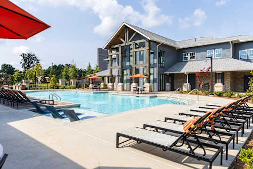 Resort style pool with lounge chairs and clubhouse at The Crest at Acworth Apartments, Acworth