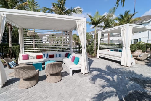 a covered patio with chairs and a hammock at The Crest at Laurel Canyon Apartments, Florida