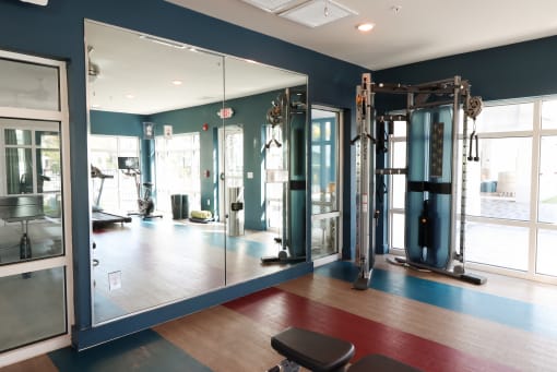 a fitness room with mirrors and exercise equipment at The Crest at Laurel Canyon Apartments, Naples, Florida