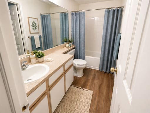 A bathroom with a toilet, sink, and shower.