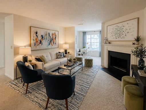 A living room with a fireplace and a painting on the wall.