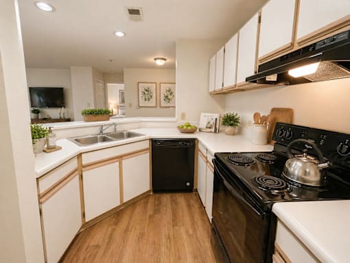 A kitchen with black appliances and white cabinets.