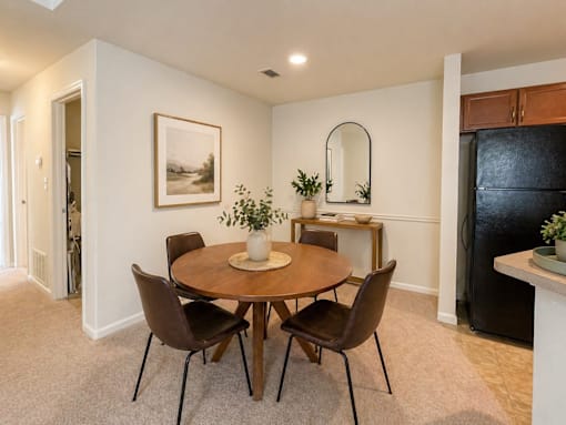 A dining room with a round table and chairs.
