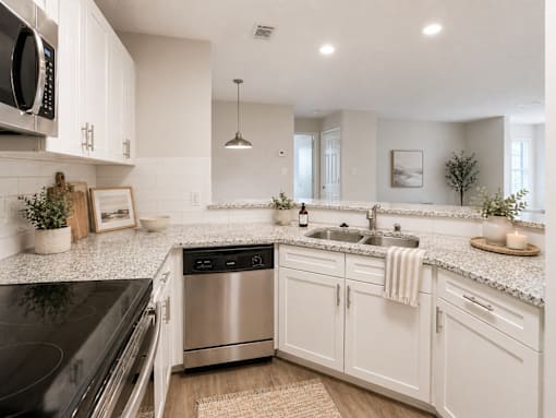 A modern kitchen with white cabinets and stainless steel appliances.