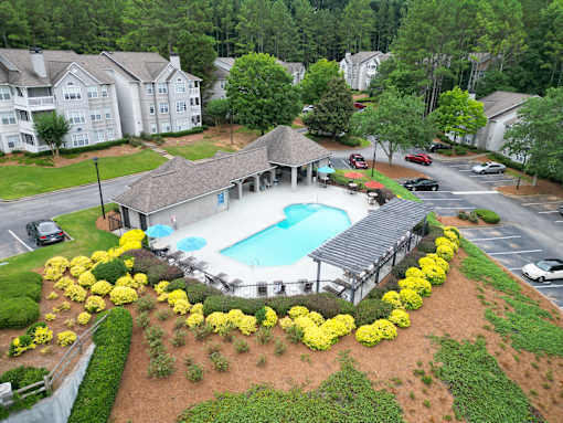 A pool surrounded by yellow flowers and green grass.