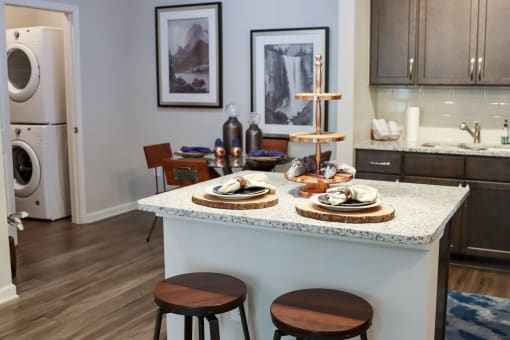 a kitchen with a counter with plates on it and a washing machine at The Crest at Laurel Canyon Apartments, Canton, GA