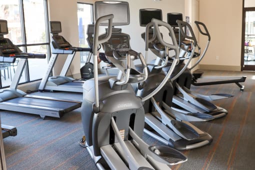 a row of exercise machines in a gym at The Crest at Laurel Canyon Apartments, Canton