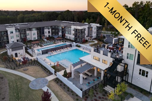 A swimming pool is surrounded by a patio and a building.