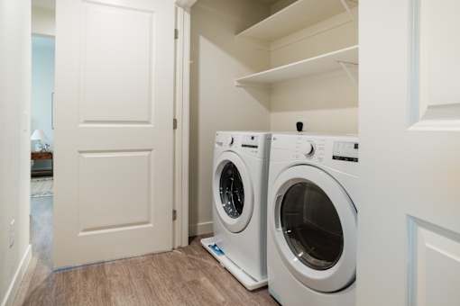 Two white front load washing machines in a laundry room.