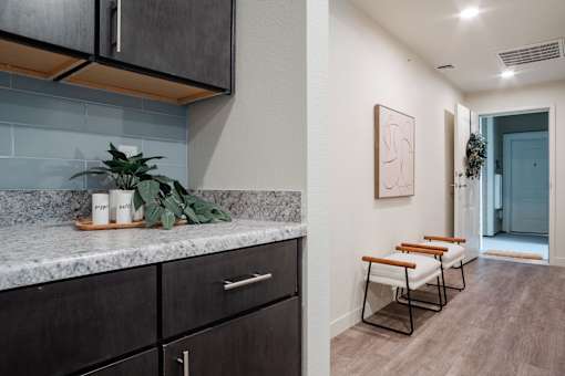 A kitchen with dark cabinets and a marble countertop.