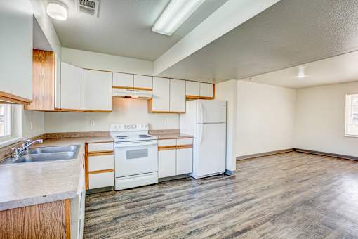 A kitchen with white appliances and wooden cabinets.