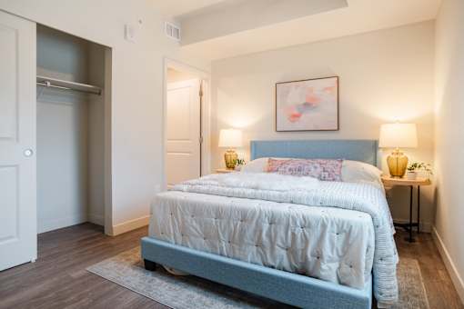 A bedroom with a large bed and a painting above it.