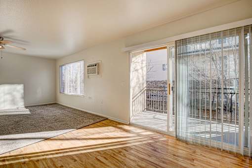 A room with a ceiling fan and a window with blinds.