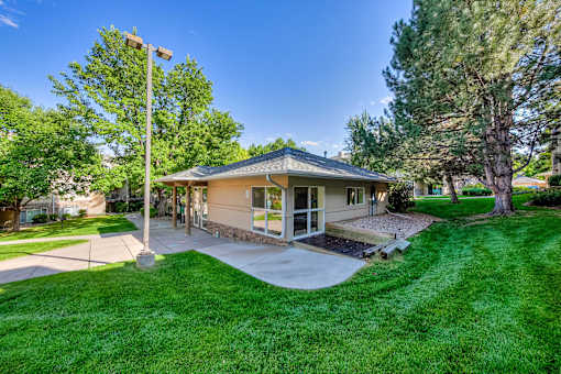 a bungalow with a porch and a yard with grass and trees