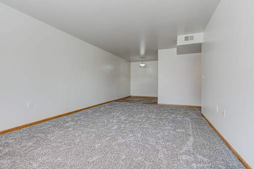 an empty living room with carpet and white walls