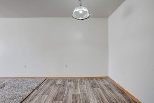 a living room with wood floors and a white wall