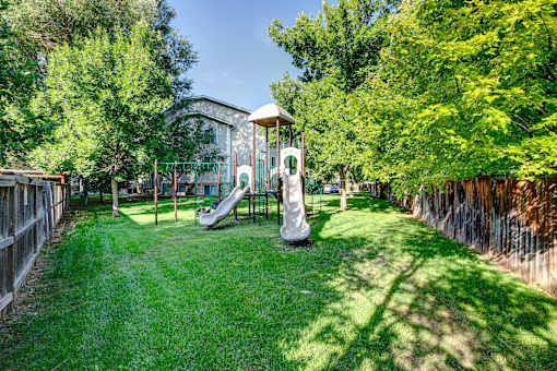 a backyard with a playground and a swing set