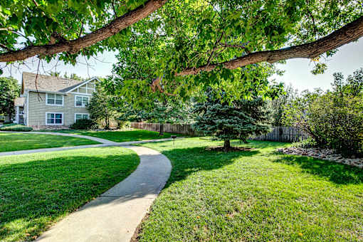 a walkway through a yard in front of a house