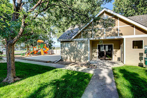 the front of a house with a yard and a playground