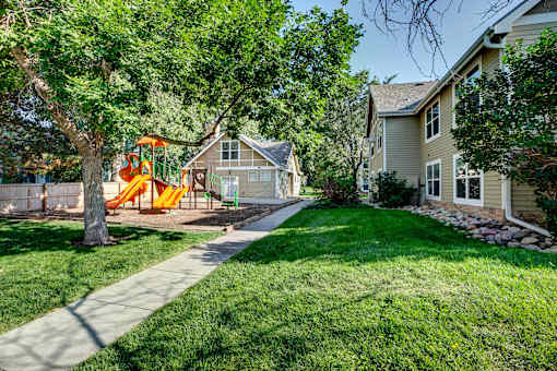 a yard with a swing set in the backyard of a home