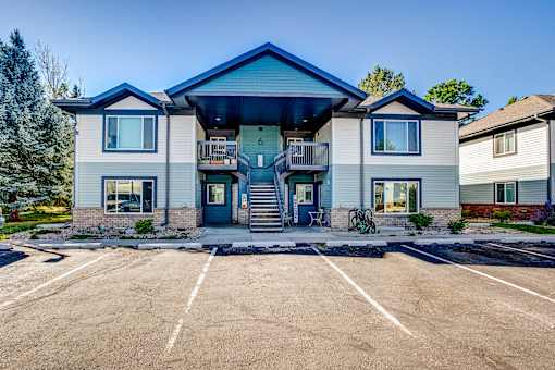 the front of a house with a parking lot and stairs