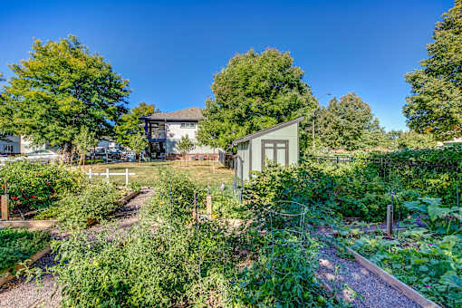 a community garden with a house in the background