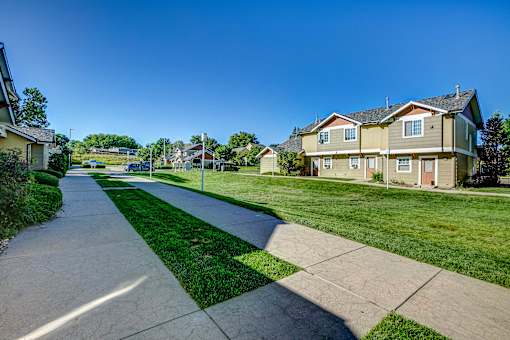 a city street with houses on either side of a sidewalk