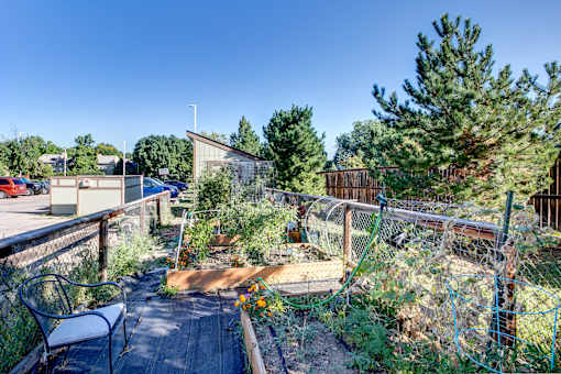 the back yard of a home with a garden and a fence