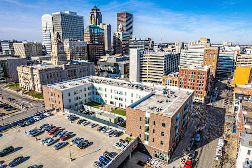 A cityscape with a large building in the foreground and several other buildings in the background.