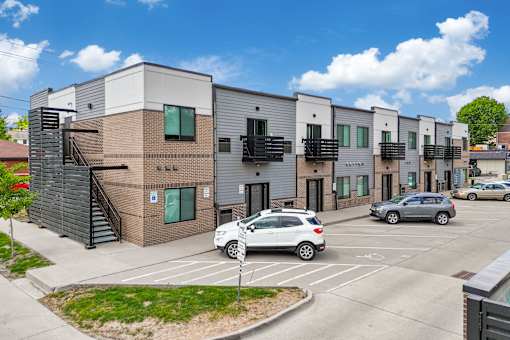 A modern building with a parking lot in front.