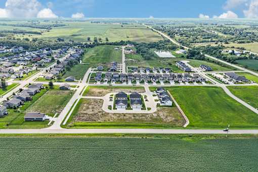 A bird's eye view of a residential area with a large green field in the foreground.
