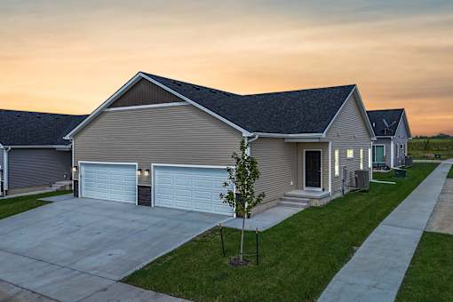 A house with a garage and a driveway in front of it.