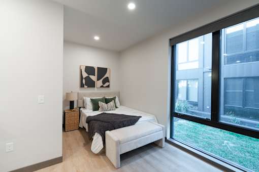 A bedroom with a large bed and a painting on the wall.