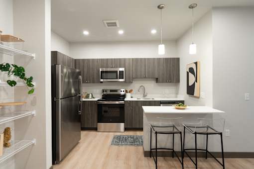 A modern kitchen with a refrigerator, stove, and sink.