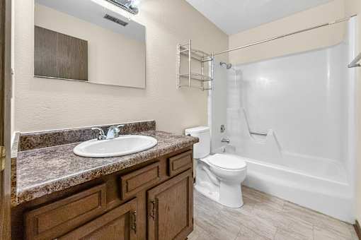 A bathroom with a sink, toilet, and bathtub.