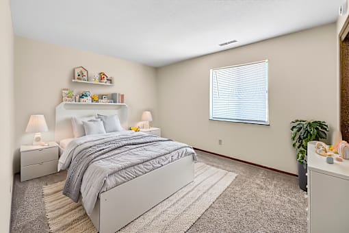 A bedroom with a large bed and a window with a blue curtain.
