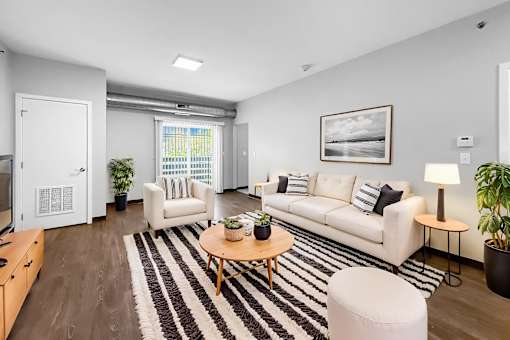 A living room with a white couch, a coffee table, and a rug.