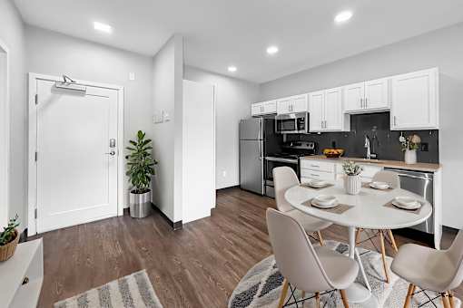 A modern kitchen with a dining table set for two.