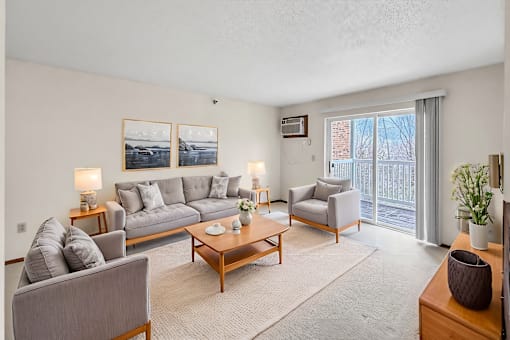 A living room with a grey couch, a coffee table, and a painting on the wall.