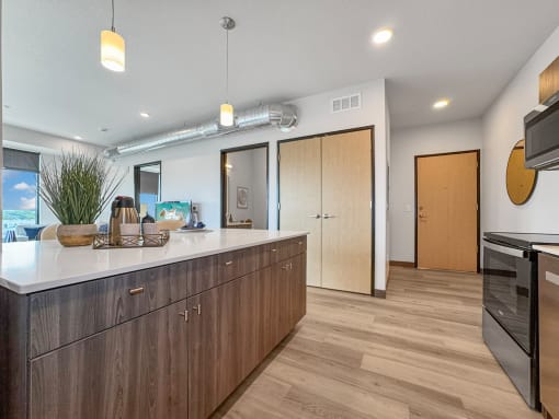 a kitchen with an island and a door to a living room