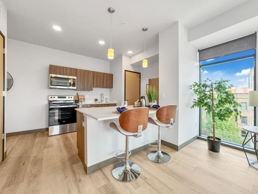 an open kitchen and dining area with bar seating and a large window