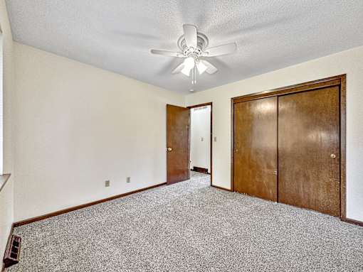 A room with a ceiling fan and two doors.