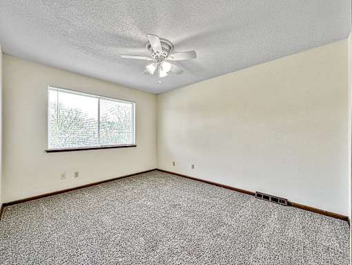 A room with a ceiling fan and a window.